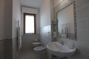 a bathroom with a sink and a toilet and a mirror at Casolare Azzurro in Acquaviva Picena