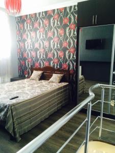 una camera da letto con un letto e carta da parati floreale di Nana's apartment a Batumi