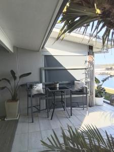 a patio with a table and chairs and a window at Studio 21 Waterfront in Yamba +19 photos