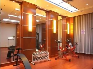 a gym with exercise equipment in a hotel lobby at Datong Tiangui International Hotel in Datong
