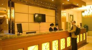 a man standing at a bar in a hotel at GreenTree Inn Fuzhou Dongxiang Longshan Express Hotel in Dongxiang