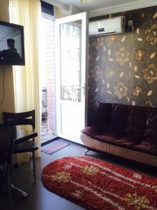 uma sala de estar com um sofá e uma porta de vidro deslizante em Nana's apartment em Batumi