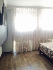 um quarto com uma cama e uma grande janela em Nana's apartment em Batumi