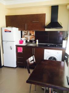 uma cozinha com um frigorífico branco e um fogão forno superior em Nana's apartment em Batumi
