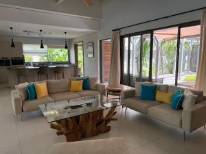 a living room with couches and a coffee table at Villa Exceptionnelle à Anahita in Grande Rivière Sud Est