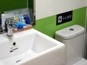 a bathroom with a white sink and a toilet at 7 Days Inn Bijie Jinsha Hebin Road in Jinsha