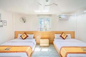 a room with two beds and a window at Sea Dragon Hotel Cát Bà & Aparment in Cat Ba +92 photos