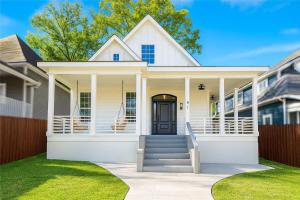 una casa blanca con puerta de entrada y césped en NEW Mercedes Benz Escape with Outdoor Theater & Bikes Minutes to Downtown & Top Attractions, en Atlanta
