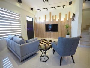 ein Wohnzimmer mit einem Sofa, 2 Stühlen und einem Tisch in der Unterkunft Season 5 Country Inn in Wujie