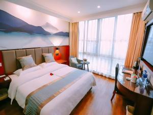 a bedroom with a large bed and a large window at GreenTree Inn MaAnshan Economic Development District Hongqi South Road Express Hotel in Ma'anshan