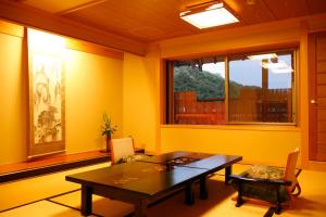 ein Esszimmer mit einem Tisch und einem Fenster in der Unterkunft Asanoya in Yumura