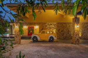 an old car parked in front of a house at The Ranch Kakkadampoyil - a VKation Experience in Kakkadampoyil