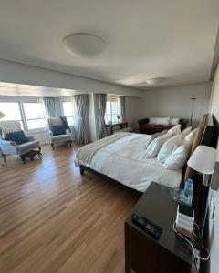 a large bedroom with a large bed and a desk at Quartier Libertador Panoramico Vista al Rio in Buenos Aires