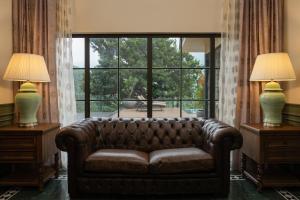 a couch in a living room with a large window at The Ranch Kakkadampoyil - a VKation Experience in Kakkadampoyil