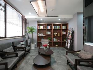 a living room with couches and a book shelf at Citytel Inn in Beijing