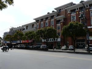 a person riding a horse down a street in front of a building at GYA Hotel Shanghai Songjiang Wanda Plaza in Shanghai