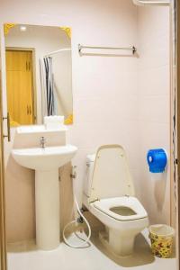 a bathroom with a white toilet and a sink at New Suanmali Hotel in Bangkok