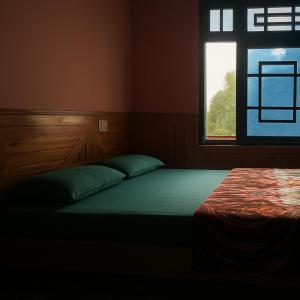 a bed in a room with a window at The Balcony at Greensmile in Shilha Village