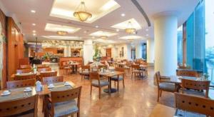a restaurant with tables and chairs in a room at Changshu Jinling Tianming Grand Hotel in Suzhou