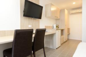 a kitchen with a television and a table at Smart Motels Bert Hinkler in Bundaberg