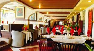 a dining room with tables and chairs in a restaurant at Purnama Hotel in Malang