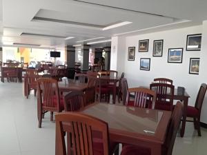 a dining room filled with wooden tables and chairs at Senesouk Hotel in Vientiane