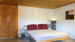 Un dormitorio con una cama con almohadas rojas. en Apartment Schweizerhof 242 Lenzerheide, en Lenzerheide 9 fotos más