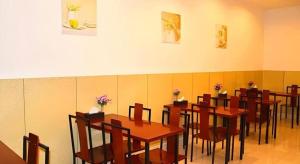 a dining room with wooden tables and chairs at GreenTree Inn Kunshan Shimao Plaza Business Hotel in Penglang