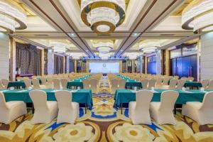 a conference room with tables and chairs and a projection screen at Country Garden Phoenix Hotel Yunfu in Yunfu