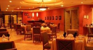 a dining room with tables and chairs in a restaurant at Hotel Honduras Maya in Tegucigalpa