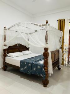 a bed with a canopy in a room at Upper Stone Bungalow in Dharga Town
