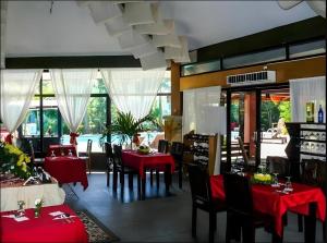 a restaurant with red tables and chairs and windows at Alta Cebu Resort in Cebu City