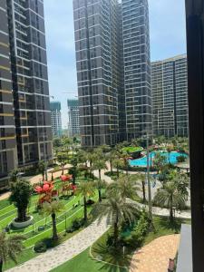 a view of a park with palm trees and buildings at Anna Vinhomes Grand Park in Ho Chi Minh City