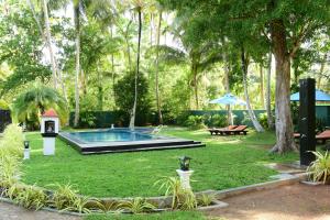 un jardín con piscina y mesa de picnic en Asnaka Villa, en Nikawatawana