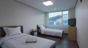 a hotel room with a bed and a television at Pyeongchang the white view in Pyeongchang 