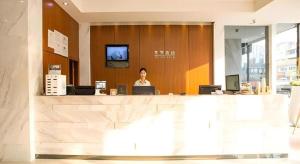 une femme assise au comptoir dans un hall dans l'établissement City Comfort Inn Nanning Guangxi University Xiuling Road Metro Station, à Nanning