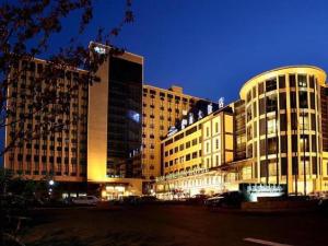 a large building with many windows at night at Qingdao Blue Horizon Hotel Licang in Qingdao
