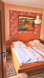 a bedroom with a bed with a painting on the wall at Ferienwohnung an der Altmühl - Apartment Gerda in Pappenheim
