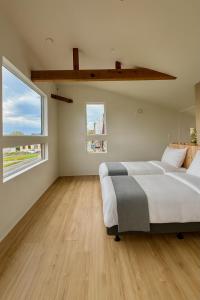 a bedroom with two beds and a large window at The Lobs Toya, Chalet Secca in Lake Toya