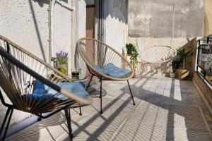 a porch with two chairs and a swing at Rock White Lotus in Kalabaka