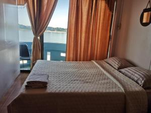 a bedroom with a bed with a view of the water at Just Mansion Hotel in Nong Khai