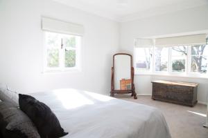 a white bedroom with a bed and a mirror at 88 Morrisset in Bathurst