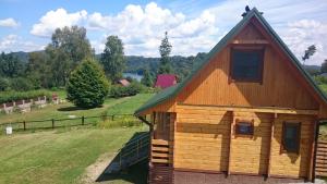 una cabaña de madera con techo de gambrel en Domki nad Soliną, en Olchowiec