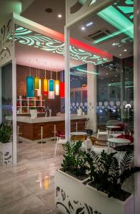 a lobby with colorful lights and tables and chairs at Nicholas Color Hotel in Ayia Napa