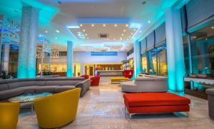 a lobby with couches and chairs in a building at Nicholas Color Hotel in Ayia Napa