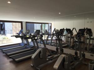 - une salle de sport avec une rangée de tapis de course dans l'établissement Aiwinco Departamento Pucón, à Pucón