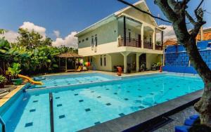 a large swimming pool in front of a house at Albis Hotel in Bandung