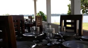 a table with glasses and plates on top of it at Naaval Hotel in Batticaloa