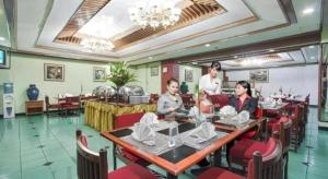 a group of people sitting at a table in a restaurant at Sahid Kawanua Hotel in Manado