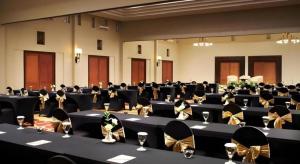a large room with black tables and chairs with wine glasses at eL Hotel Kartika Wijaya Batu in Malang +181 photos